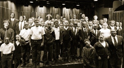 a group photo of 40 school children with park rangers and the NPS Director