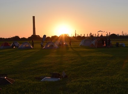 seven tents in an open field at sunset