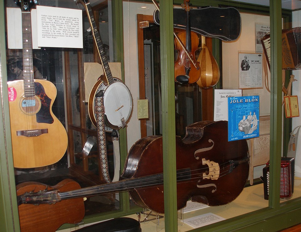 Display case with guitar, banjo, accordion, and other instruments Display case with guitar, banjo, accordion, and other instruments