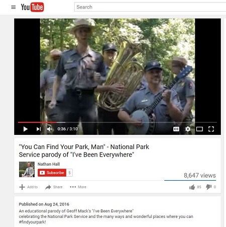 A screen capture of a YouTube video featuring uniformed park rangers singing and playing the tuba and trumpet