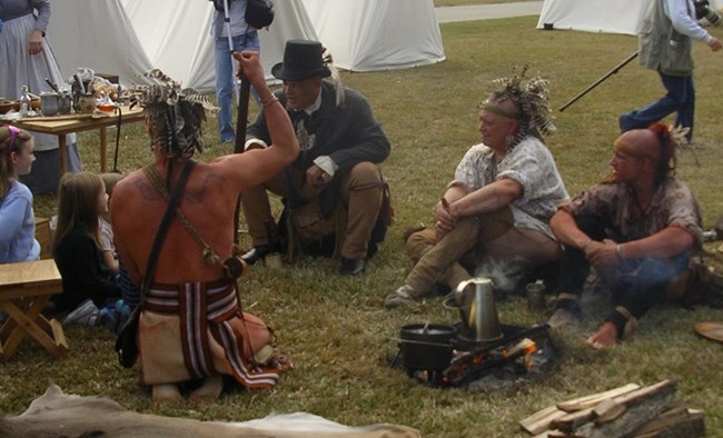 Living history volunteers dressed as Choctaw Indians at 2012 Battle of New Orleans anniversary event Men dressed as 1815-era Choctaw Indians talk to girls at living history event