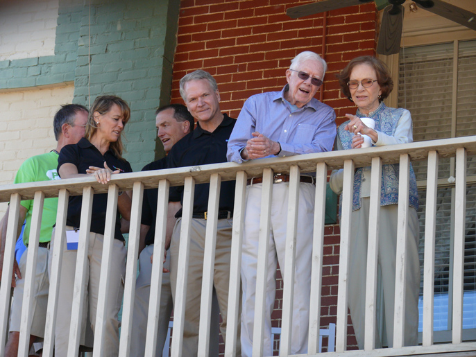 President and Mrs. Carter view the parade route from the balcony of the Plains inn and Antique Mall