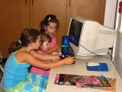 Image of kids using a microscope in the classroom.