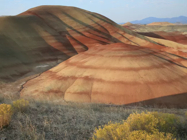 Photograph of the painted hills, weathered rocky hills with alternating tan and rust colored layers