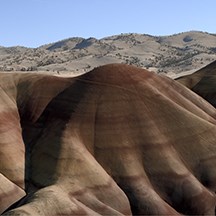 tan and red hills underneath a clear blue sky