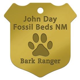 A gold BARK Ranger badge with text "John Day Fossil Beds NM Bark Ranger"