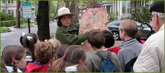 A ranger shows students a historical map of the Brookline neighborhood of JFK's youth