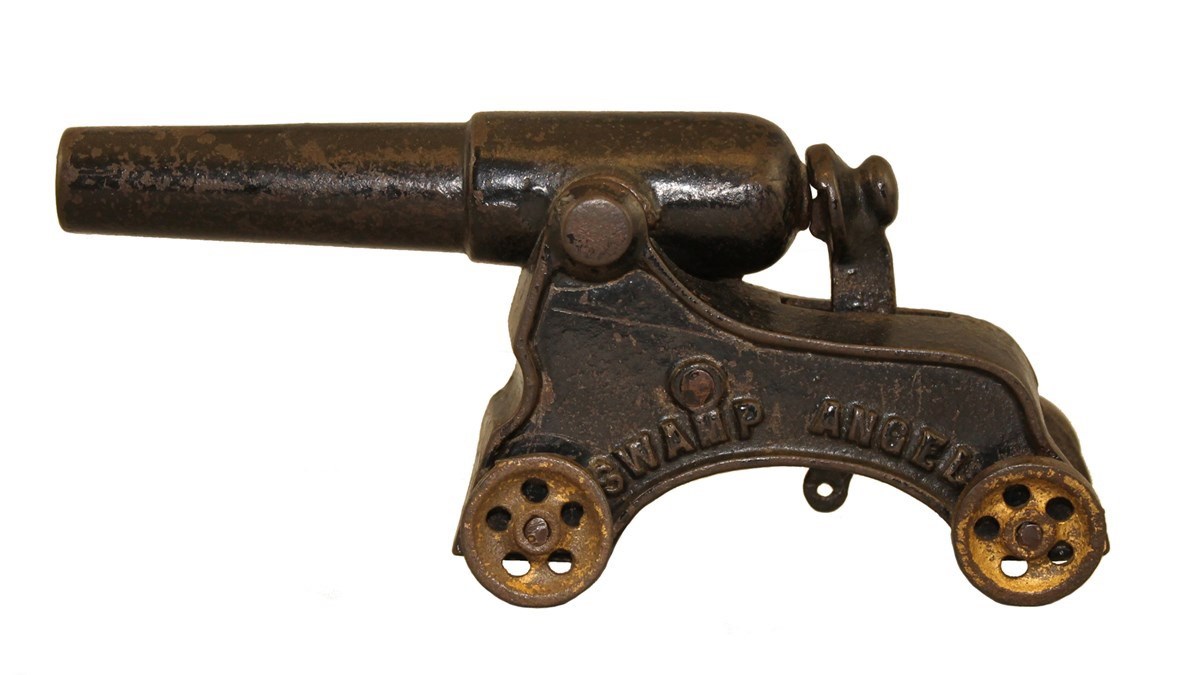 metal toy cannon mounted on carriage with four wheels, side stamped SWAMP ANGEL