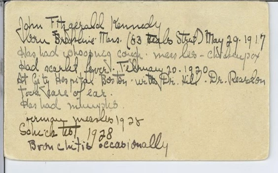 JFK's childhood illness card Handwritten, cursive notes in dark ink on a beige paper note card.
