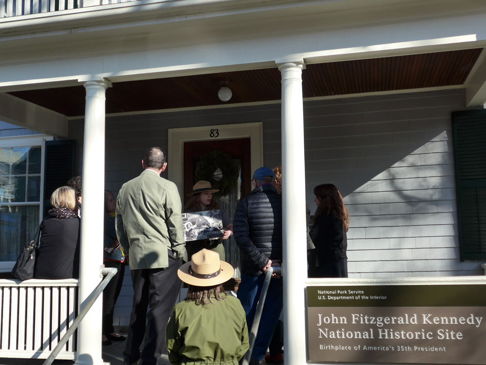 A park ranger shows a historic photograph to visitors to help them learn about the park