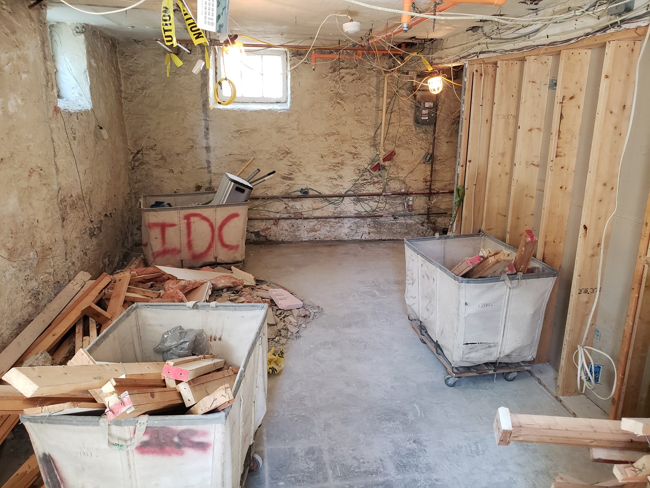 A view of the basement visitor center with building materials and cables visible.