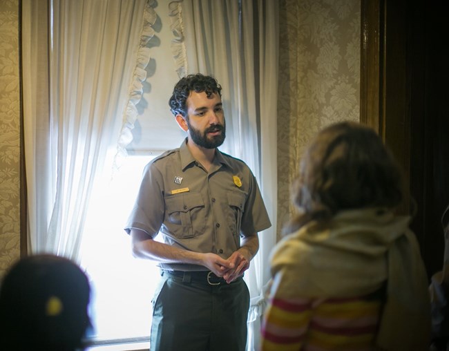 Park Ranger giving guided House Tour to visitors.