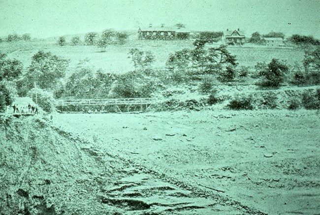 A hillside with a barn and farmhouse