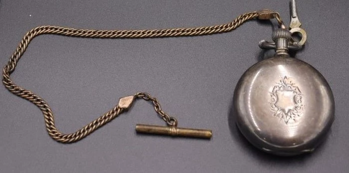 Pocket watch A 19th century metal and glass pocket watch with a chain and key attached. It was gifted to Johnstown Flood National Memorial in 1991.