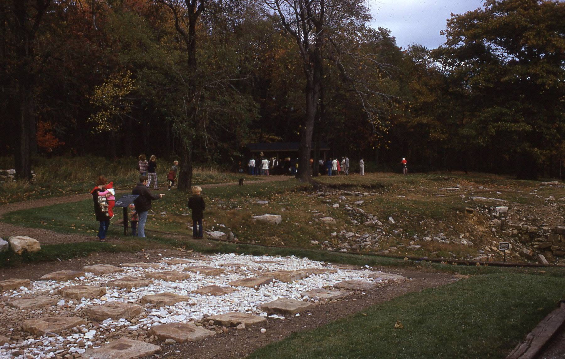 People looking at a stone foundation