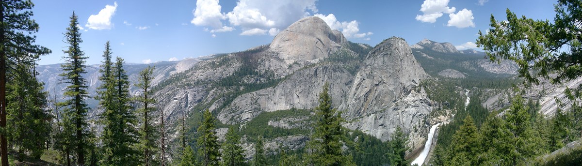 Modern photograph of Yosemite National Park. A vista of mountains and trees.