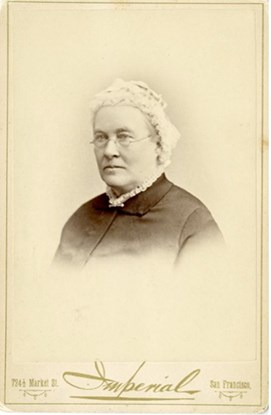 Historic portrait of a senior woman who is dressed well and wearing a cap.