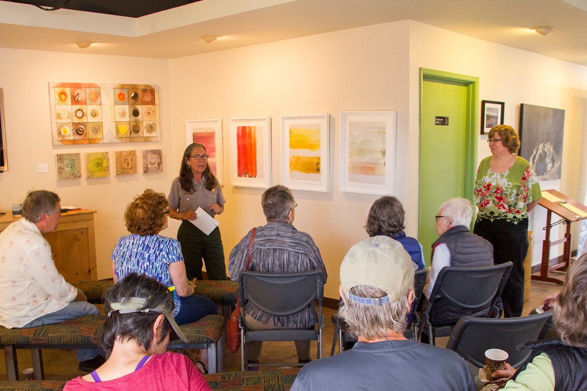 Color photo of a ranger introducing Artist-in-Residence Lauren Eisenberg Davis for a presentation. Photo credit: NPS / Brad Sutton Color photo of a ranger introducing Artist-in-Residence Lauren Eisenberg Davis for a presentation. Photo credit: NPS / Brad Sutton