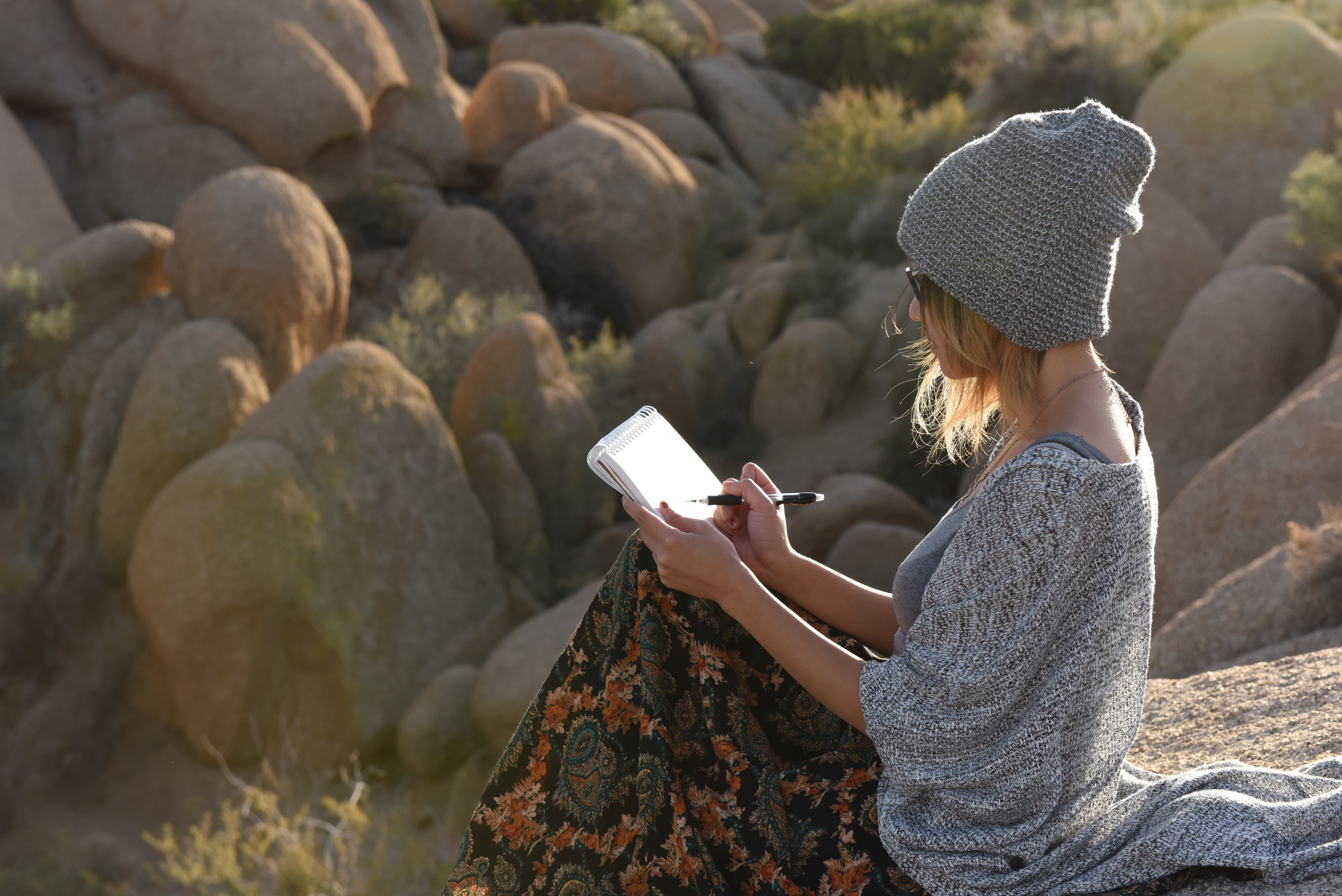 Artist sketching while sitting on a large rock formation