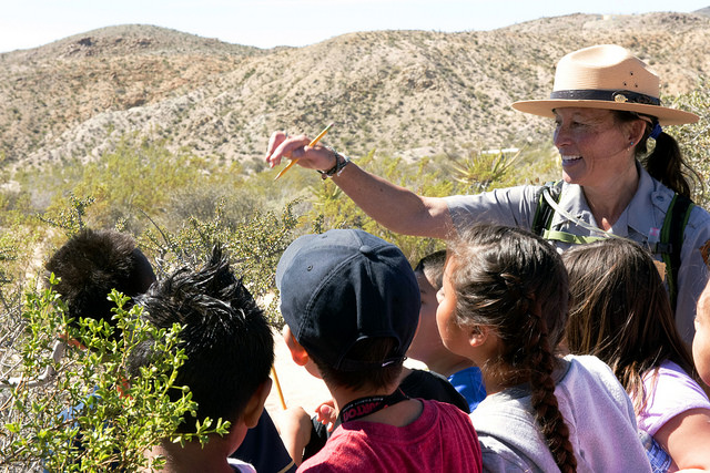 Ranger Cynthia points out a creosote bush to students on a field trip Ranger Cynthia points out a creosote bush to students on a field trip