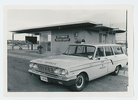 A black and white image of a vehicle and a building that says Cottonwood Visitor Center