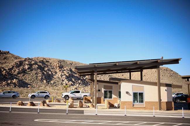 Entrance station with a line of cars and rock in the background