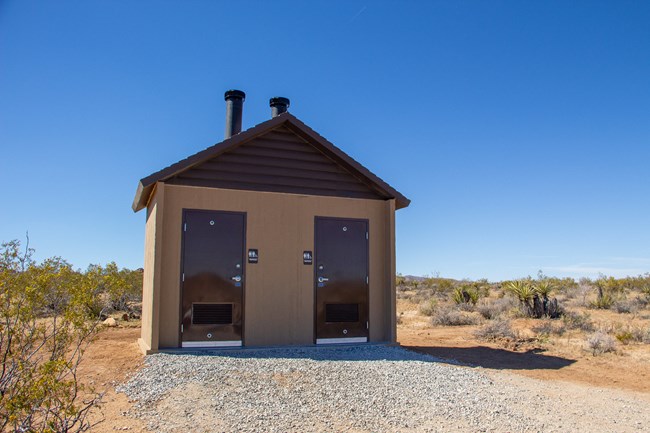 a square building with brown doors and restroom signage
