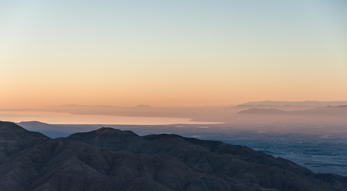 Looking out over the Salton Sea from Keys View. It is just after sunset and the light is very pink. The foreground mountains are blue. Looking out over the Salton Sea from Keys View. It is just after sunset and the light is very pink. The foreground mountains are blue.