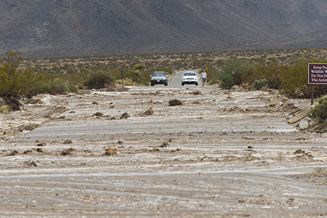 Water and debris wash across the park road on August 26, 2015.