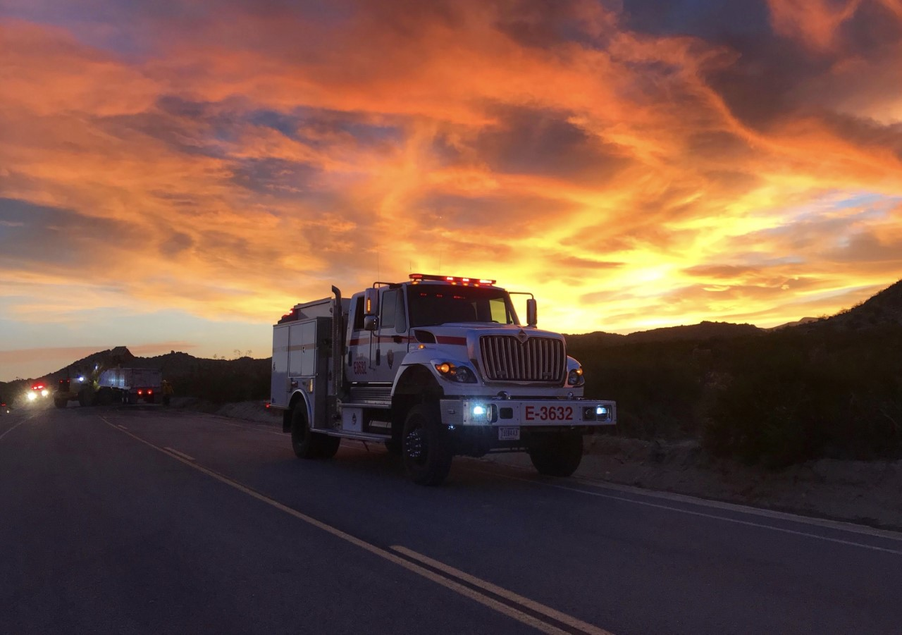 Fire Truck A fire truck on a road during sunset.
