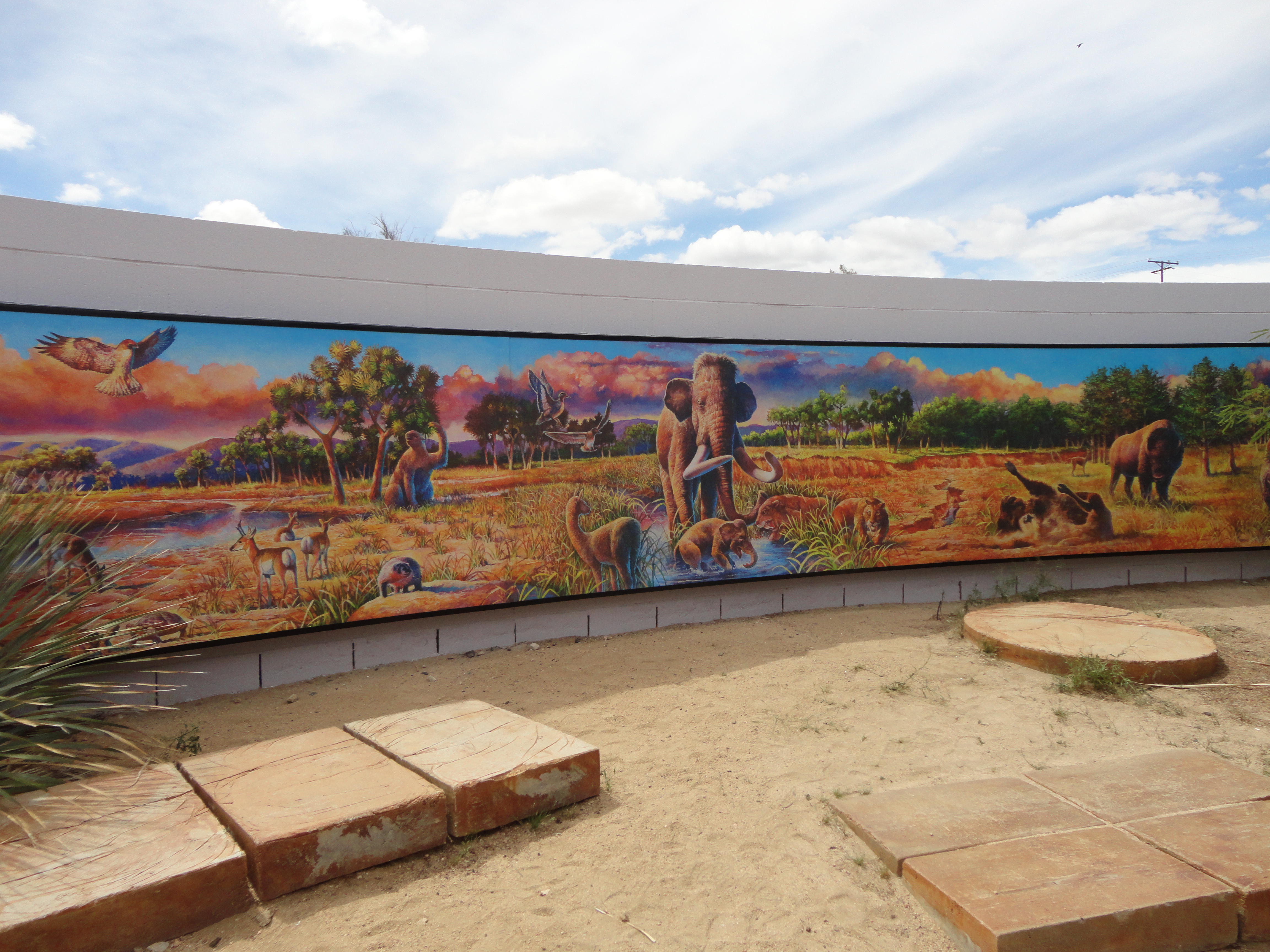A mural illustrating Ice Age animals of Joshua Tree National Park including mammoth, ground sloth, saber-toothed cats, and bison on the outdoor patio of Joshua Tree Visitor Center.
