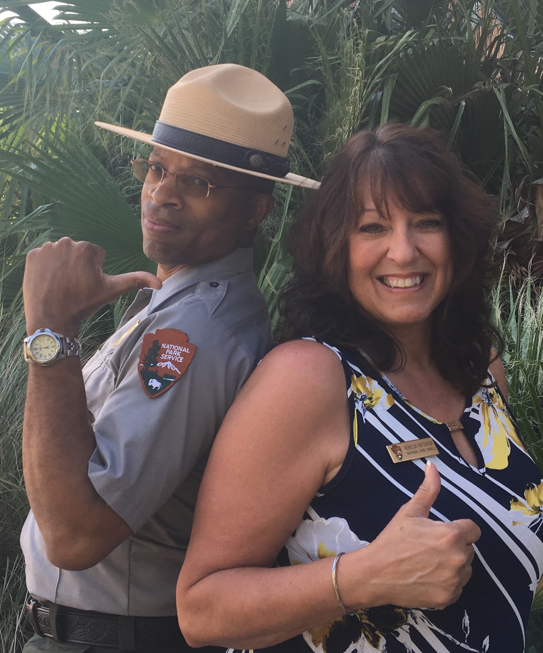 Two park rangers smile at the camera.