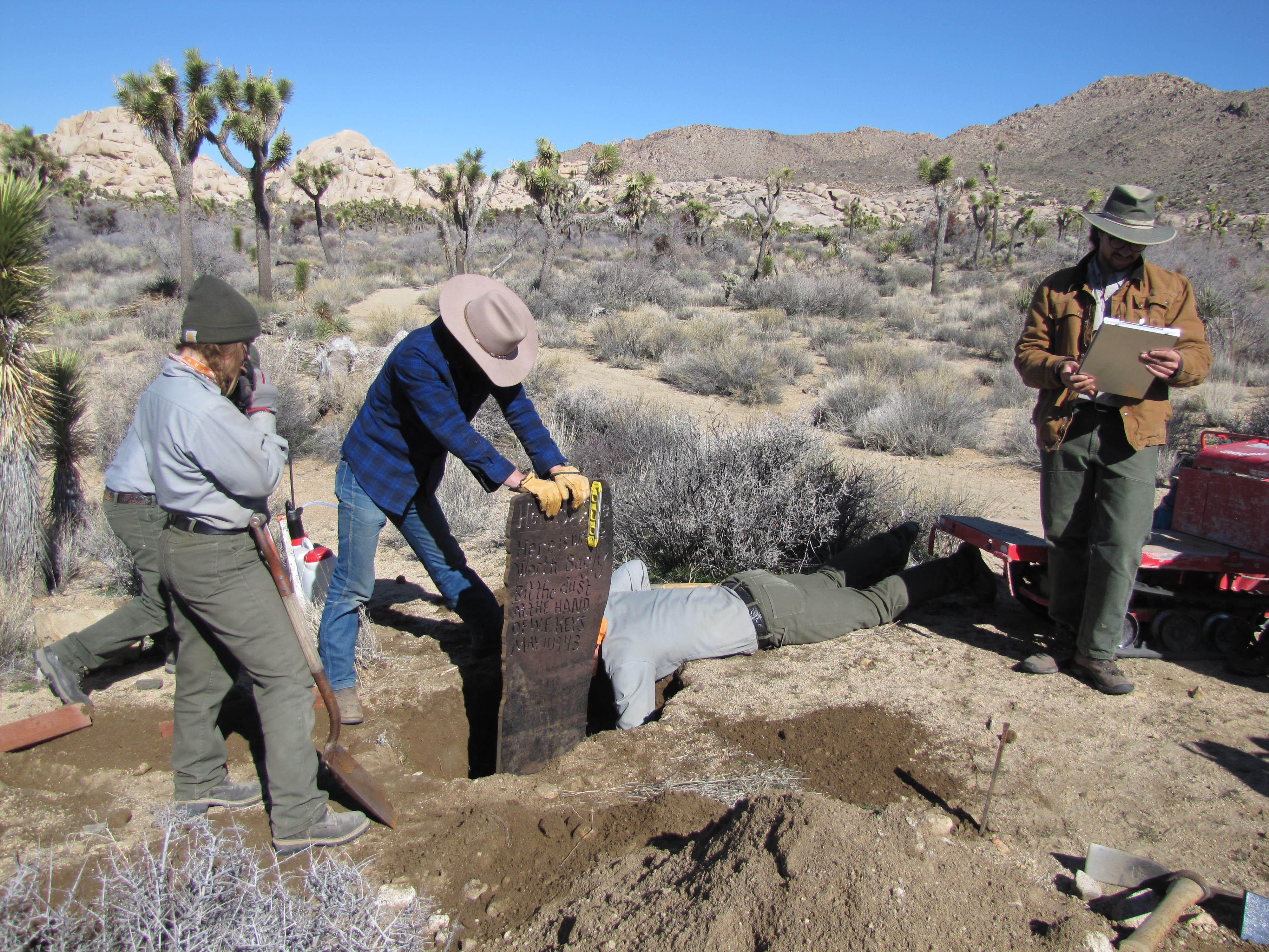 Crews work to replace and set a replica marker.