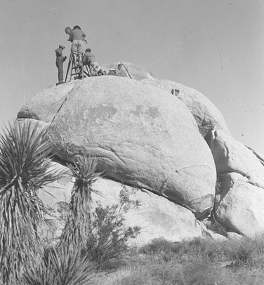 A film crew set up atop boulders