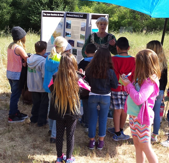 student writes notes at an Anza Trail station student writes notes at an Anza Trail station