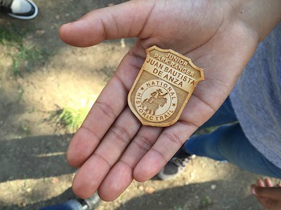 A wooden badge reading Junior Ranger in an open palm