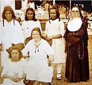 Five girls in light-colored clothing and one nun.