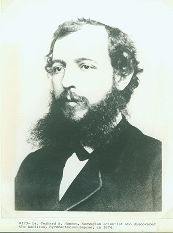 A black and white portrait photo of a bearded man in a suit.