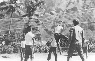 A black and white image of people playing volleyball