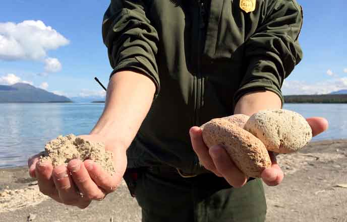 Ranger holds ash in right hand and pumice in left