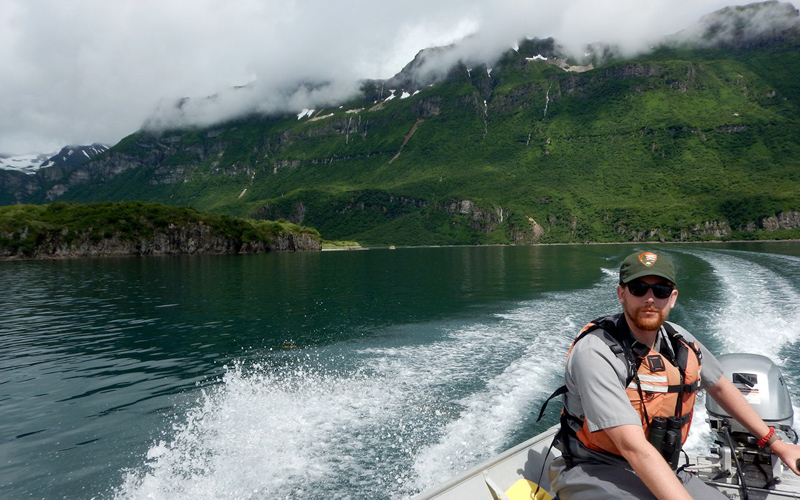 Ranger Robert drives a motor boat through the bay