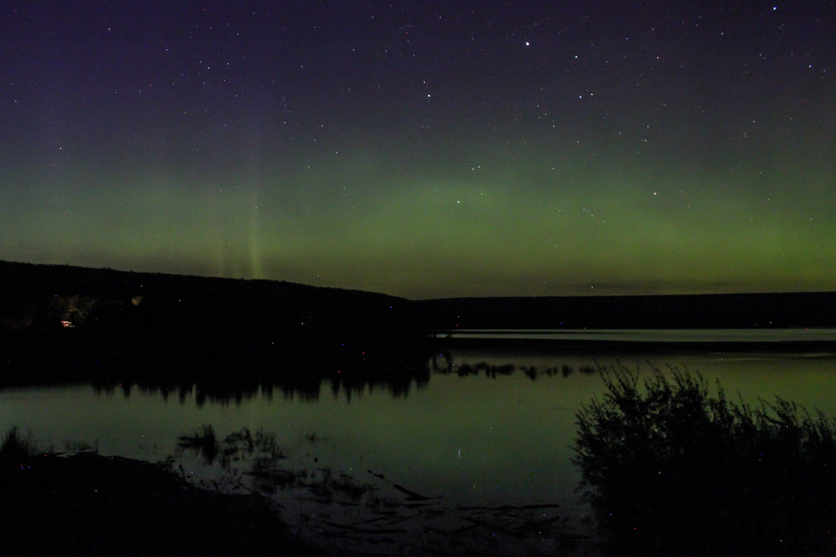 The Aurora glows over mountains