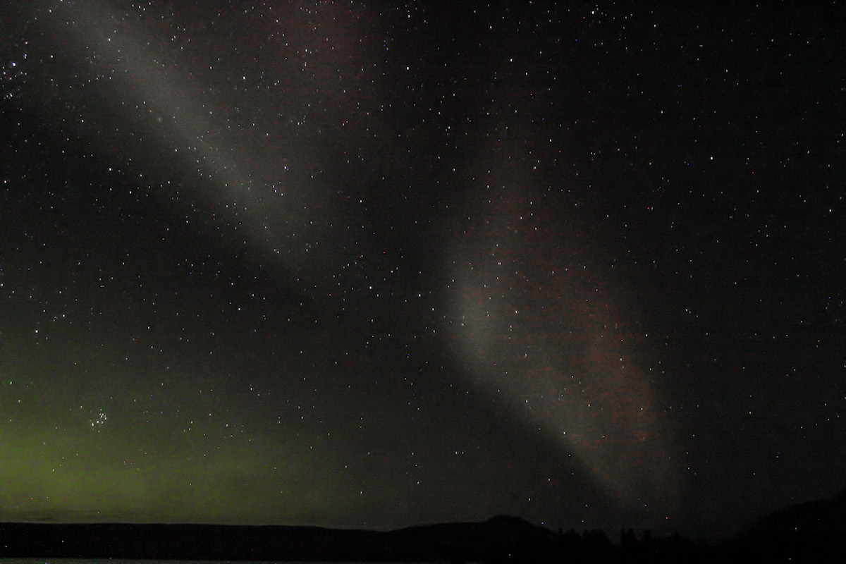 The Aurora glows over mountains