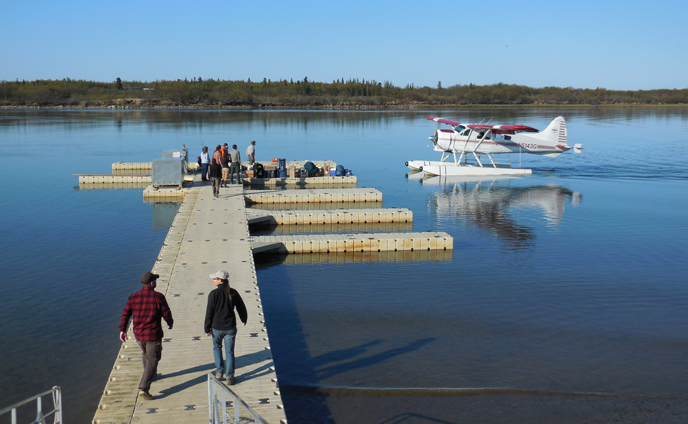 Park staff wait on dock for arriving float plane