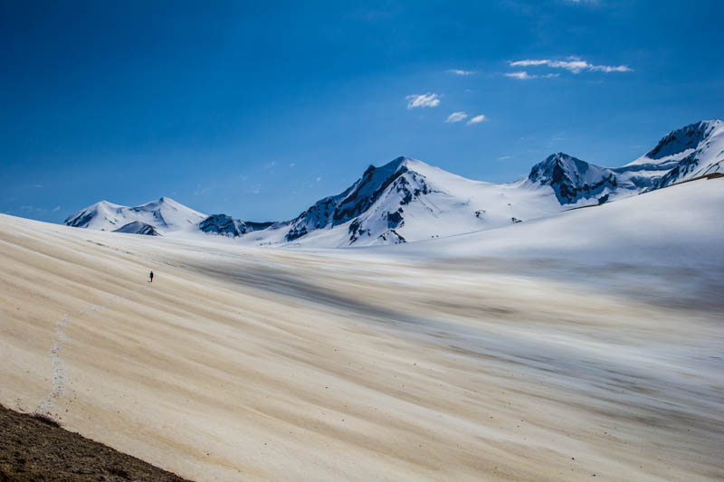 Rangers hike into the distance through a snow field