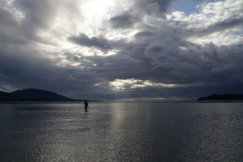 A ranger in the tidal zone looking for flounder