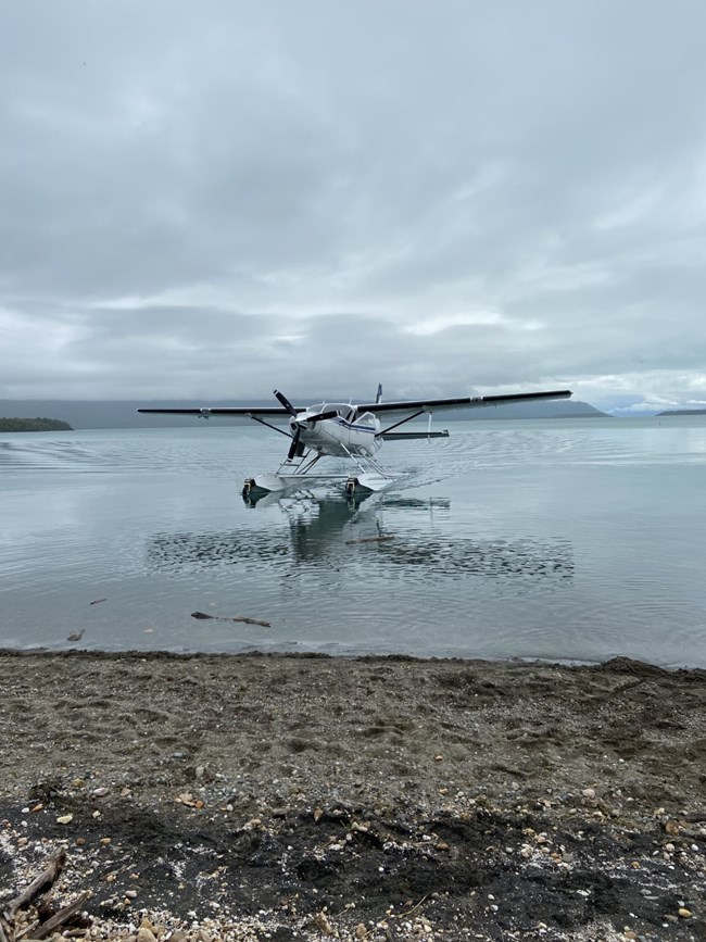 A float plane on water headed to shore