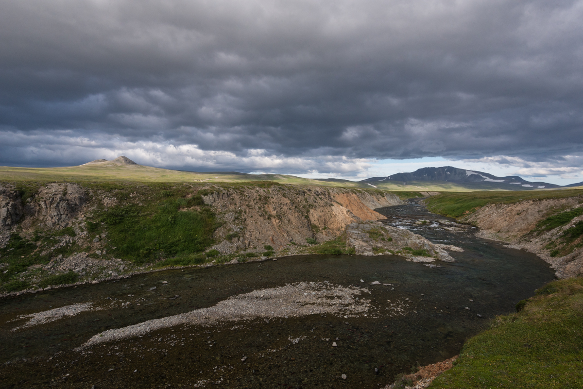 A stream with distant mountains in evening light