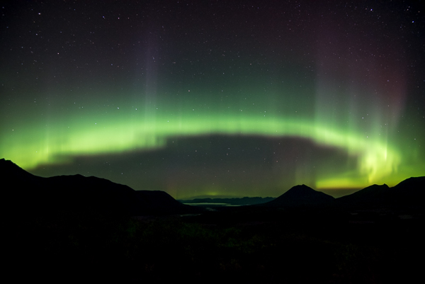 The Aurora Borealis Green Aurora Lights over Silhouetted Mountains