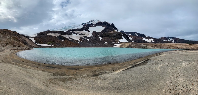 A blue lake at the base of a moutain